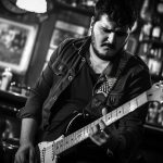 vista-monocromatica-de-una-persona-tocando-la-guitarra-electrica